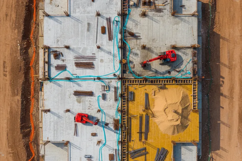 An aerial view of a construction site overlaid with color-coded 12-class segmentation masks